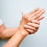 Elderly woman holding her arthritic hands