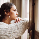 pensive woman in front of the window