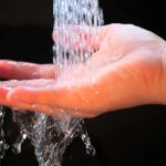 Hands in running water